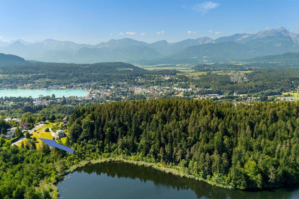 Panoramablick auf die umliegende Landschaft mit Seen und Bergen unter blauem Himmel.