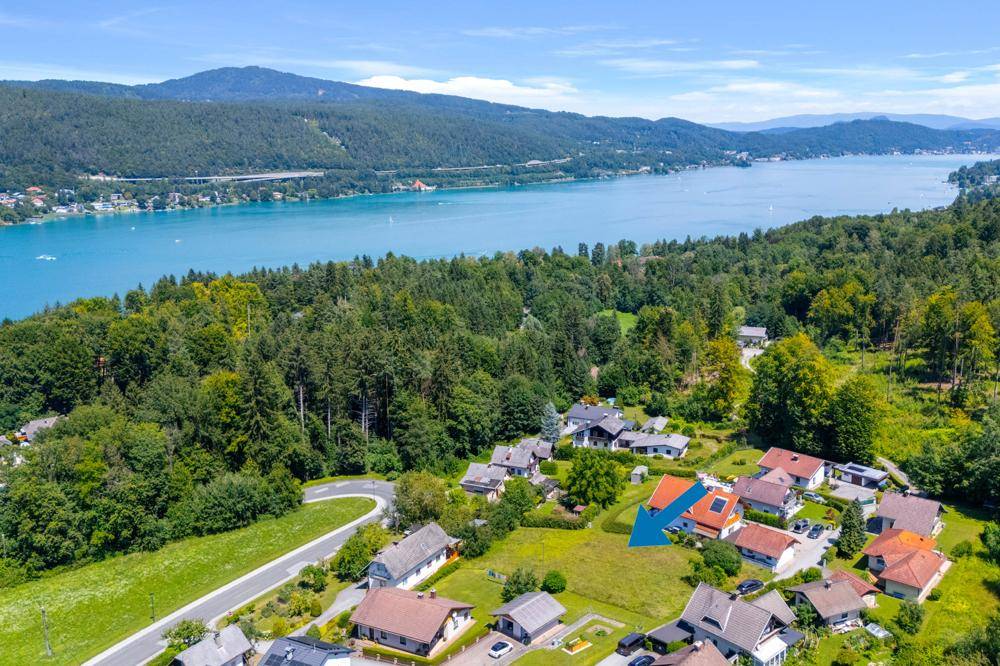 Panoramablick auf das Grundstück und die umliegende Landschaft mit See und Bergen.