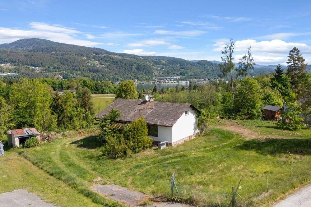 Freistehendes Haus auf einem Hügel mit weitem Blick auf den See und die umliegende Naturlandschaft.