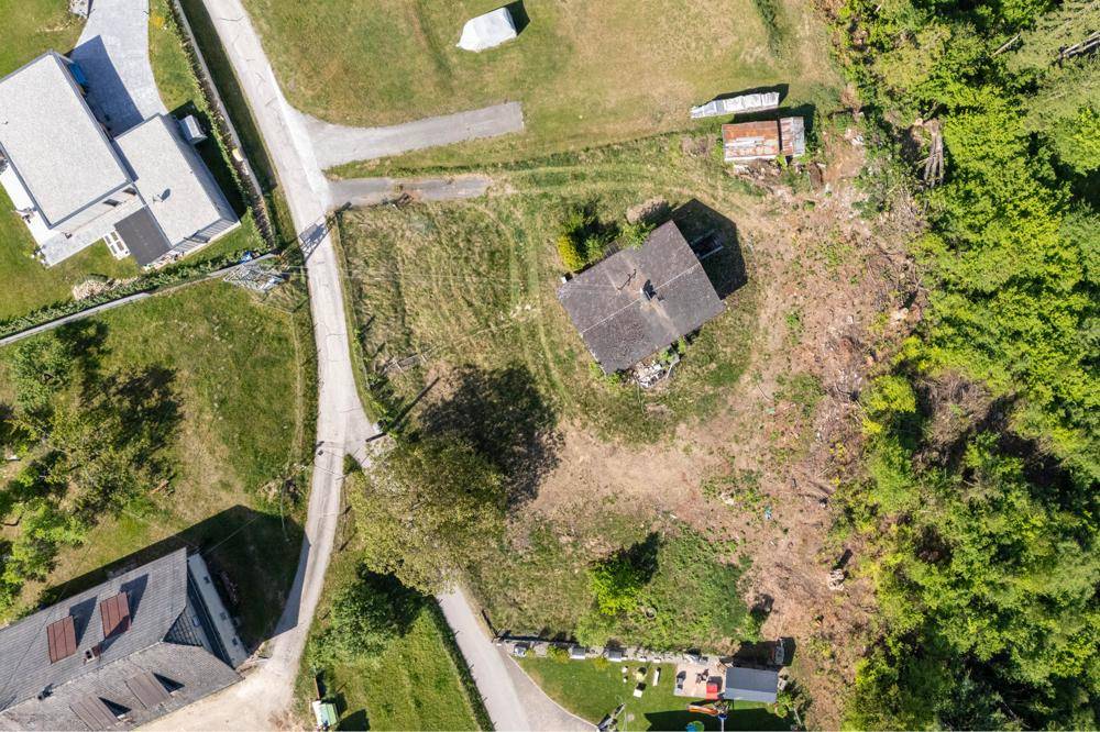 Vogelperspektive eines Grundstücks mit einem Haus, Zufahrten und viel Grünfläche in ländlicher Umgebung.