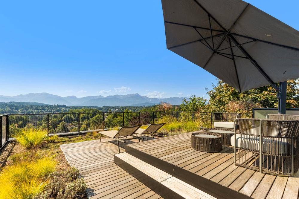 Großzügige Dachterrasse mit Sonnenschirm und Lounge-Möbeln, ideal zum Entspannen mit Panoramablick.