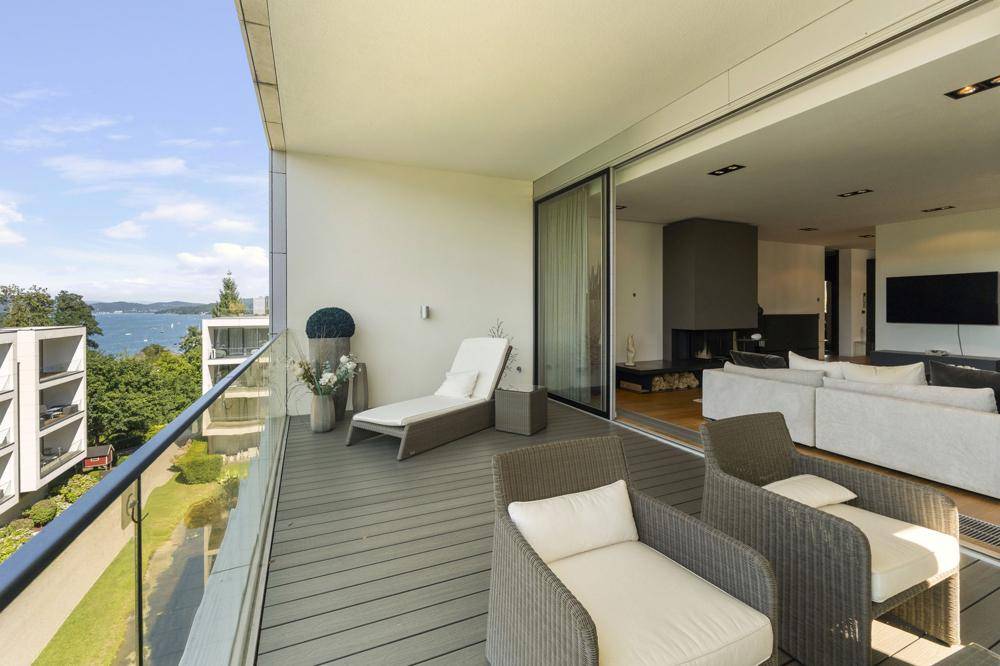 Großer Balkon mit Sitzgelegenheiten und herrlichem Blick auf den See und die grüne Landschaft.