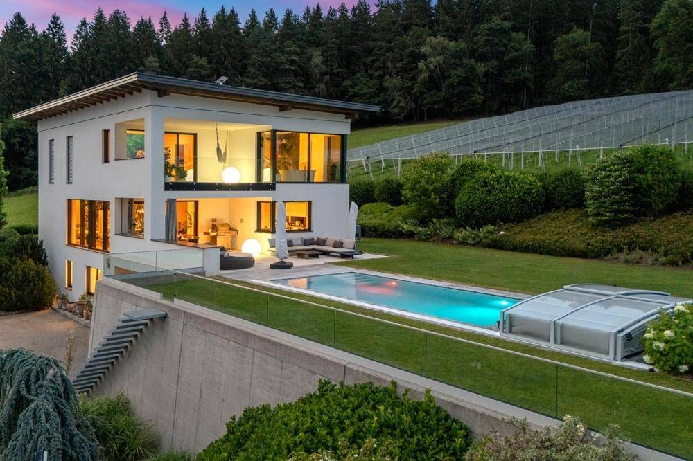 Luxuriöse Villa mit Infinity-Pool und weitläufigem Garten, eingebettet in eine idyllische Hügellandschaft.