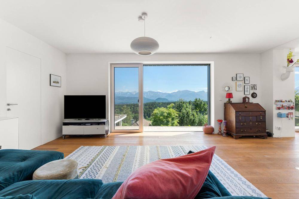 Helles Wohnzimmer mit großen Schiebetüren, die einen spektakulären Bergblick freigeben.
