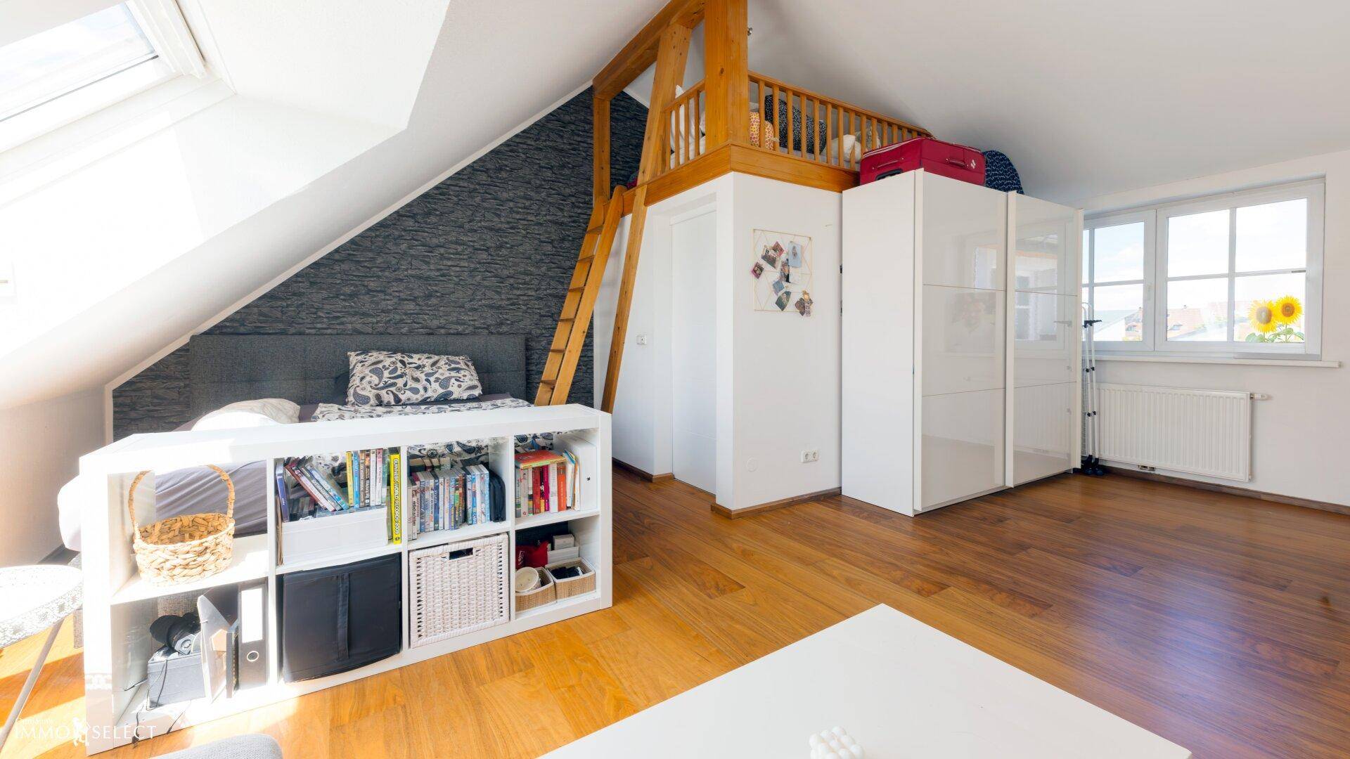 Gemütliches Schlafzimmer im Dachgeschoss mit Holzboden und integriertem Hochbett.