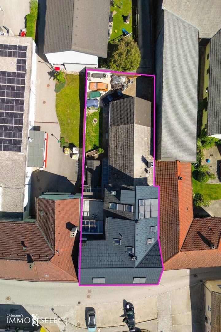 Luftaufnahme des Grundstücks mit umliegenden Gebäuden und verschiedenen Dachflächen.