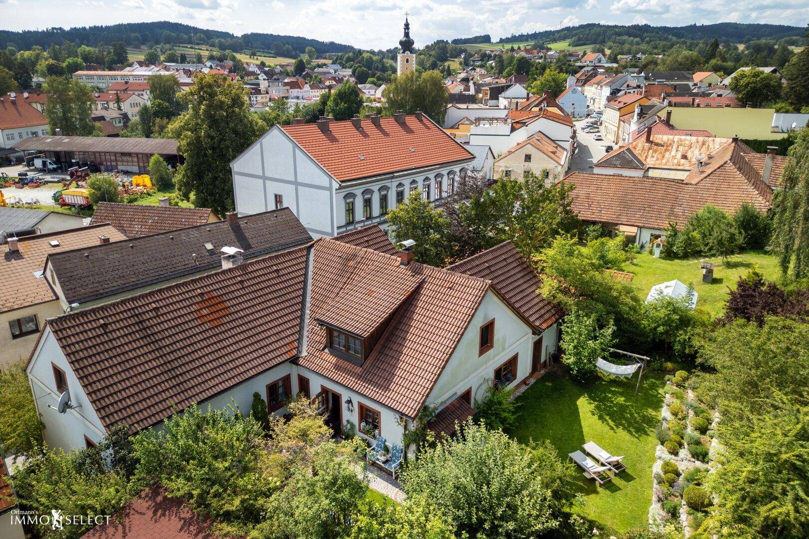 Panoramablick aus der Luft auf das Anwesen und das malerische Dorf mit Kirchturm.