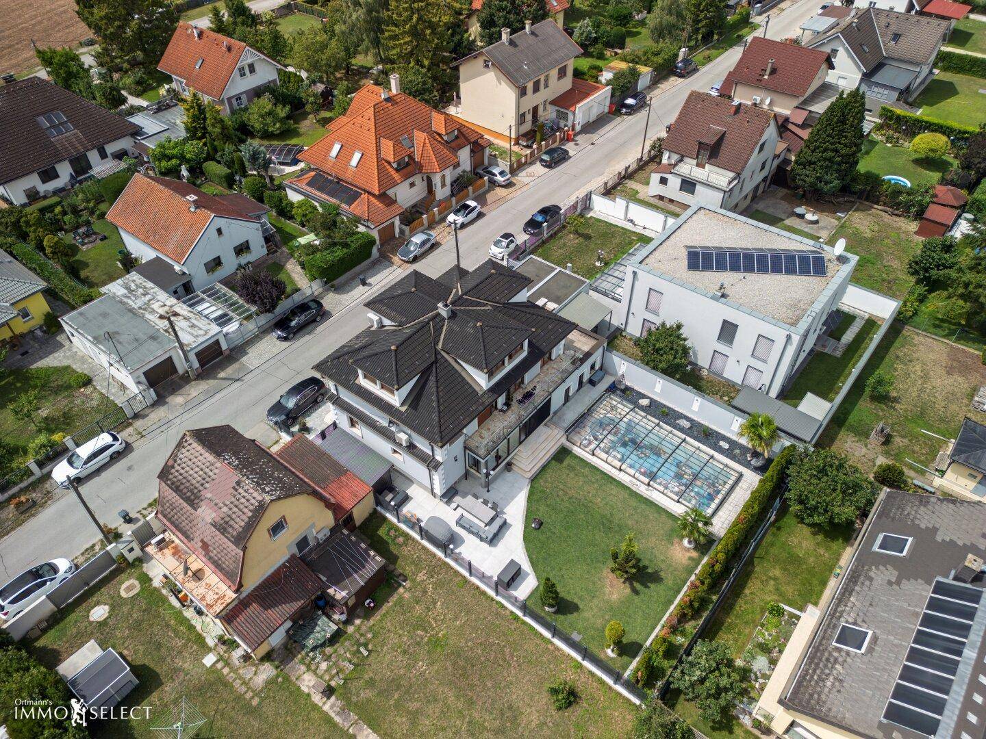 Weitläufige Luftaufnahme des Wohngebiets mit Einfamilienhäusern und viel Grün, in einer ruhigen Lage.