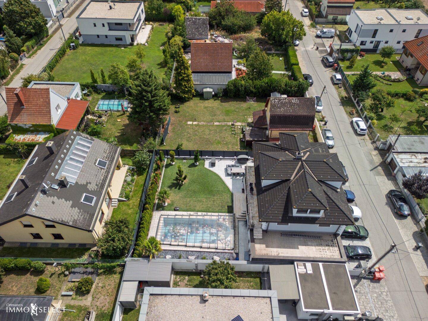 Luftaufnahme des Wohngebiets mit Einfamilienhäusern, Gärten und angrenzendem Feld, idyllisch gelegen.