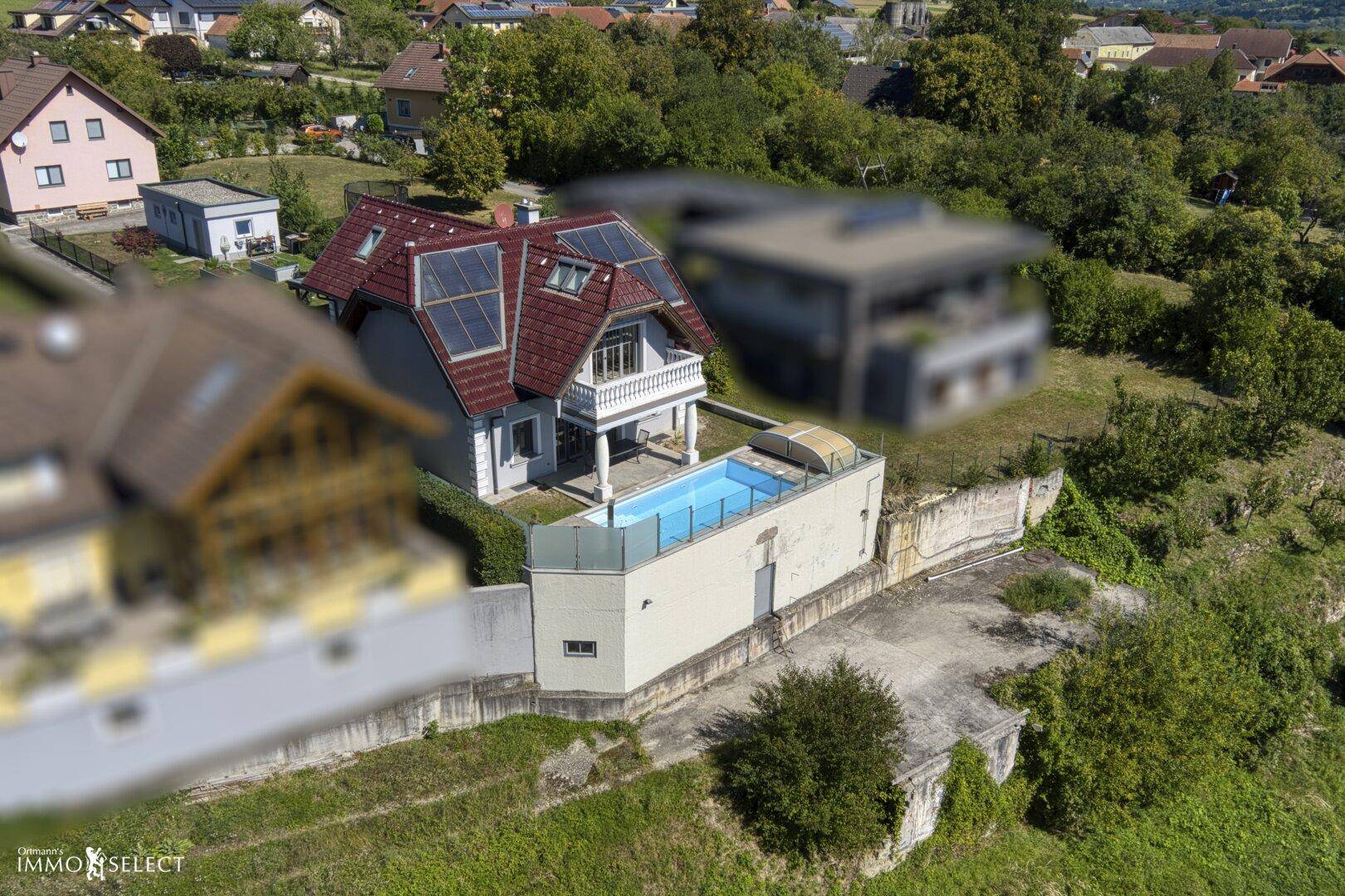 Luftaufnahme des Hauses mit Pool, Solaranlage und umliegender grüner Landschaft.