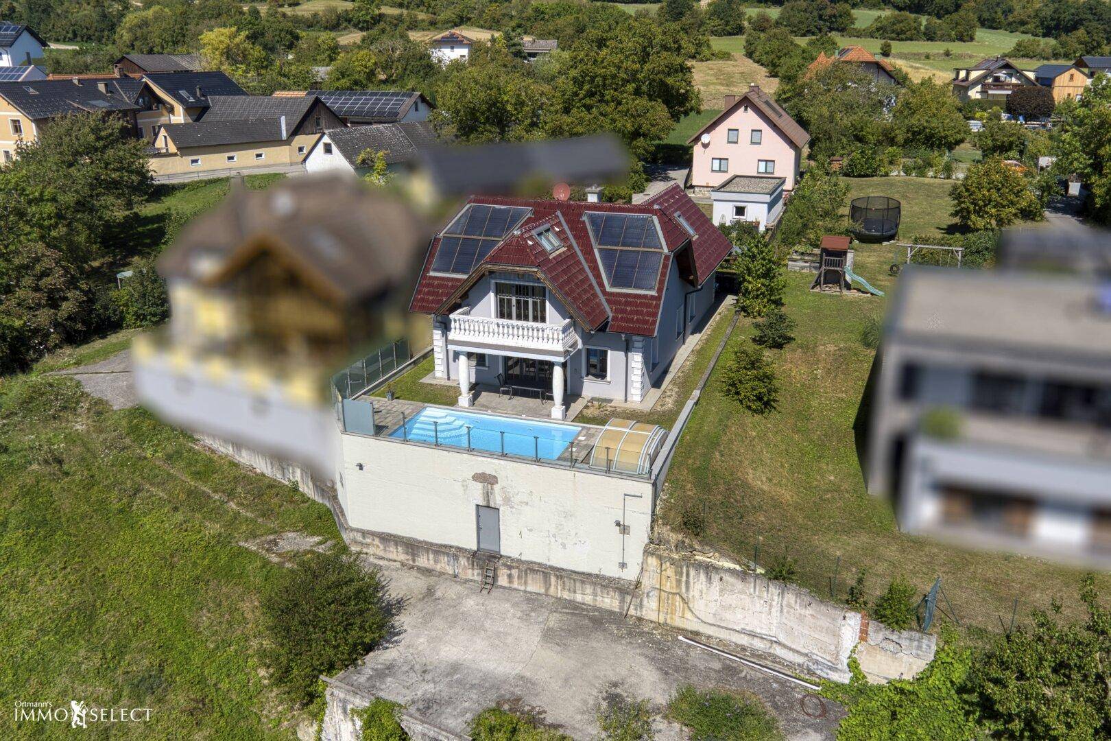 Luftaufnahme des Hauses mit Pool, Solaranlage und umliegender grüner Landschaft.