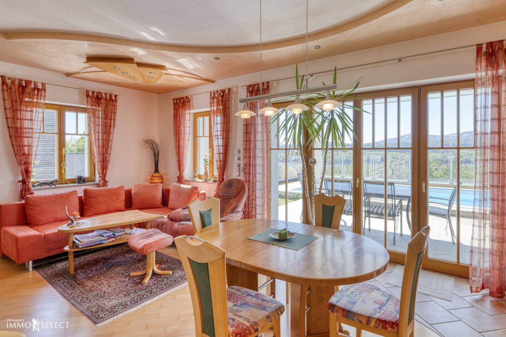 Heller Wohn- und Essbereich mit Holzboden, großen Fenstern und Zugang zur Terrasse.