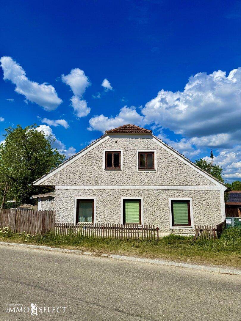 Direkte Ansicht der Hausfassade mit mehreren Fenstern und dem traditionellen Ziegeldach.