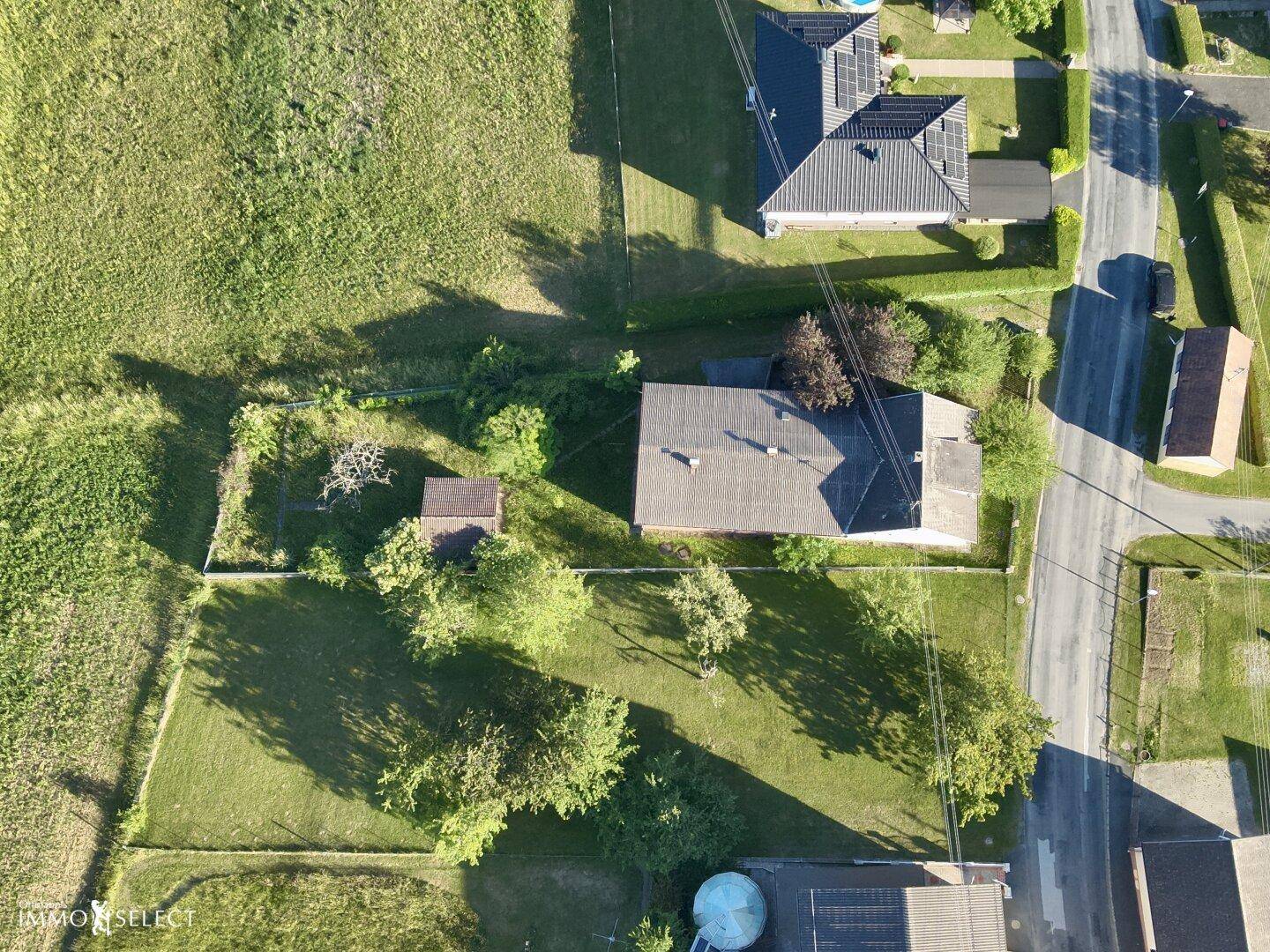 Senkrechte Luftaufnahme des Anwesens mit Haus, Garten und angrenzender Straße in ländlicher Lage.