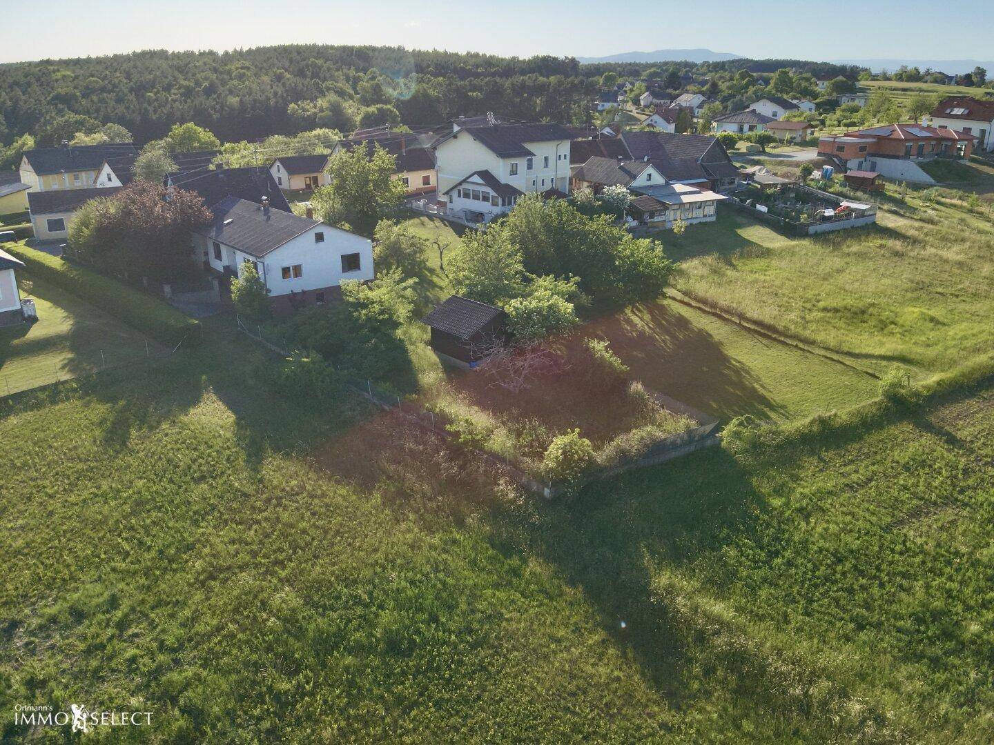 Luftaufnahme des Anwesens bei Sonnenuntergang, eingebettet in eine idyllische grüne Landschaft.