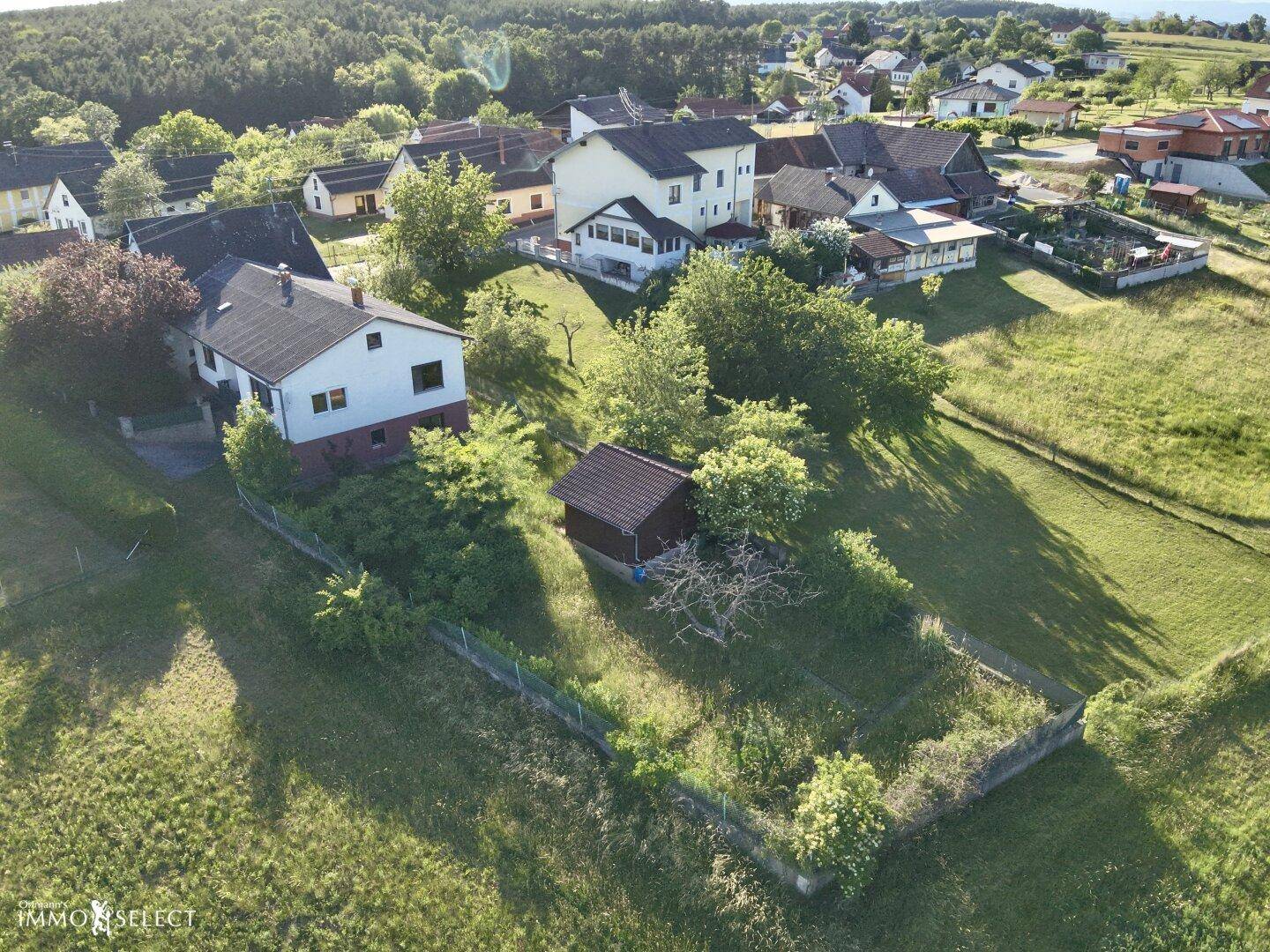 Panoramablick aus der Luft auf das Anwesen, umgeben von weitläufigen grünen Wiesen und Wäldern.