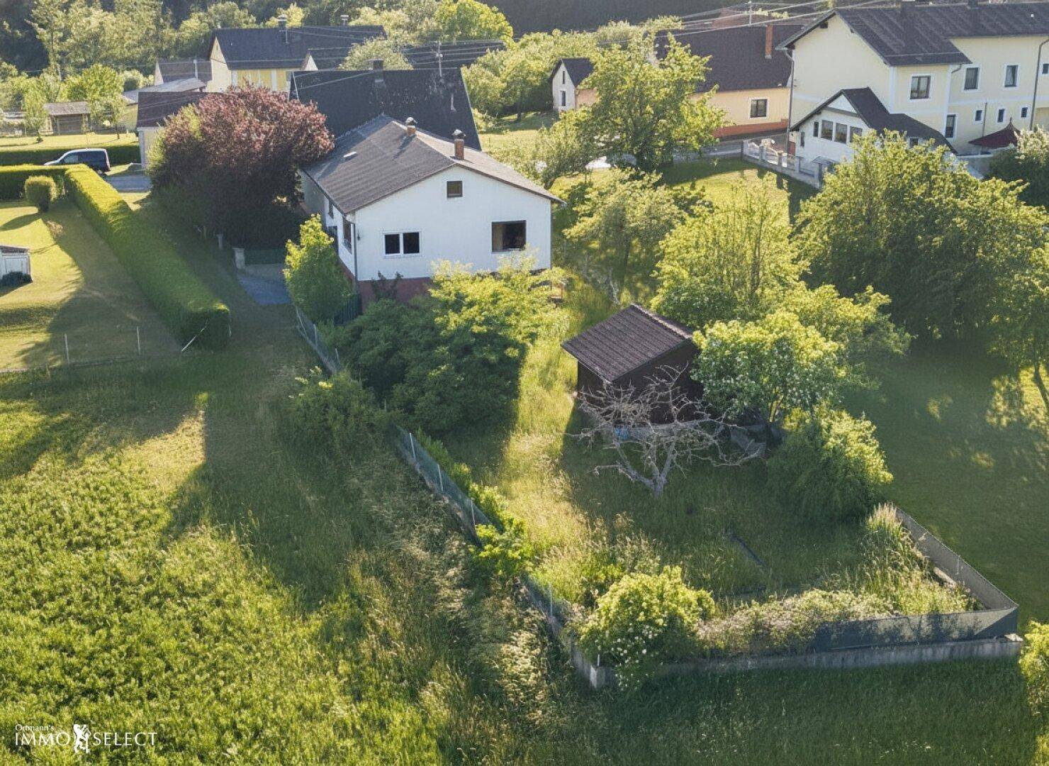 Panoramablick aus der Luft auf das Anwesen, umgeben von weitläufigen grünen Wiesen und Wäldern.