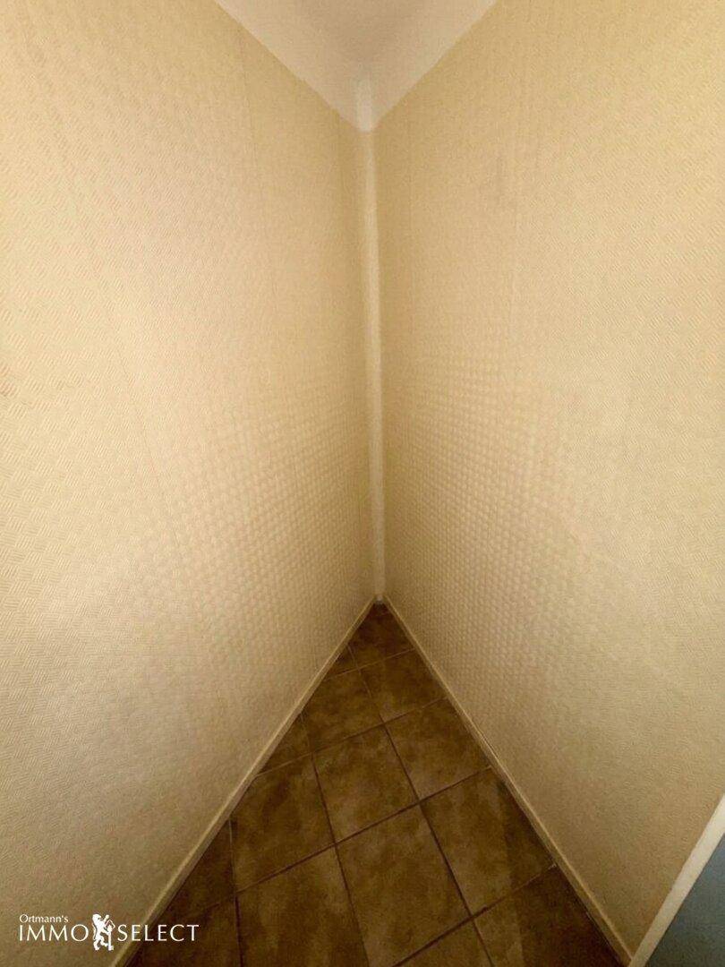 Kleiner Abstellraum mit Fliesenboden und hellen Wänden, ideal für zusätzlichen Stauraum.