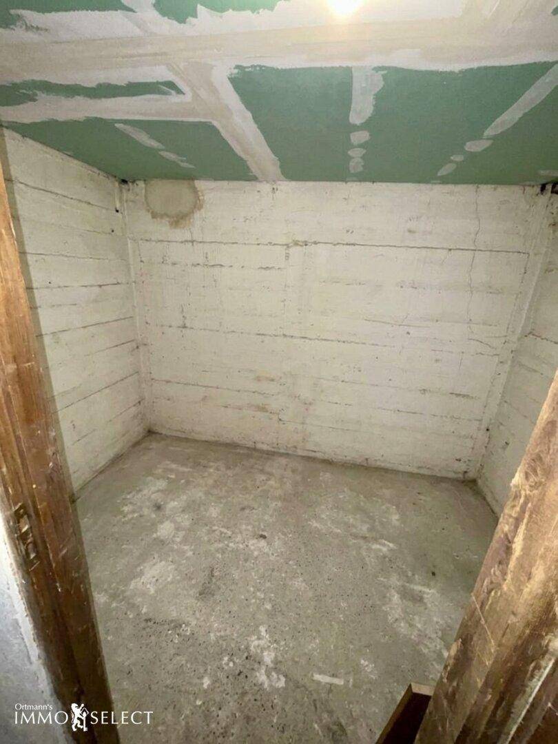 Unfertiger Kellerraum mit Betonboden und rauen Wänden, ideal als Stauraum oder Werkstatt.