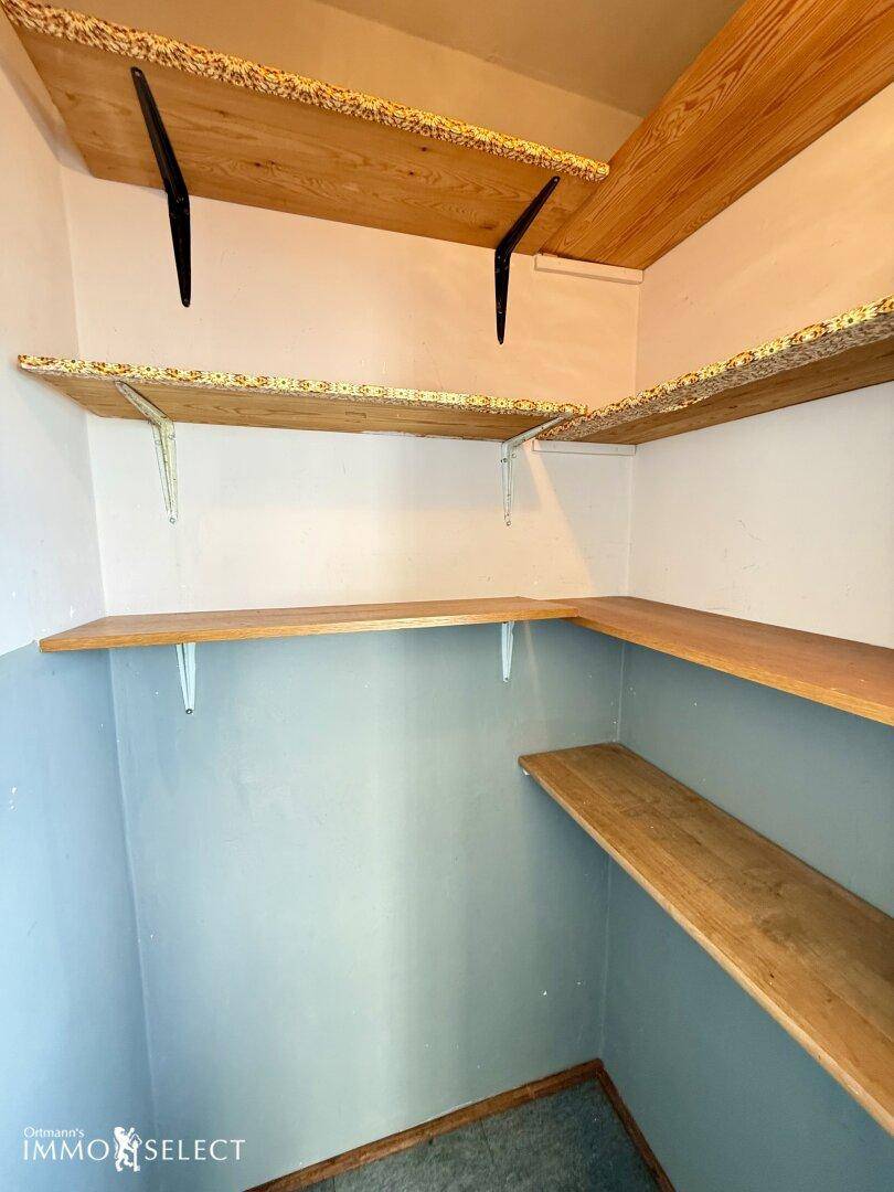 Praktischer Abstellraum mit Holzregalen für zusätzlichen Stauraum.