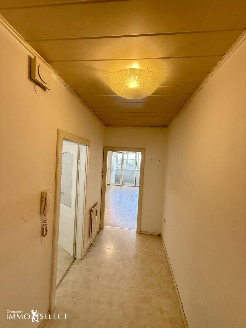 Flur mit Holzdecke, PVC-Boden und Gegensprechanlage, führt in weitere Räume.