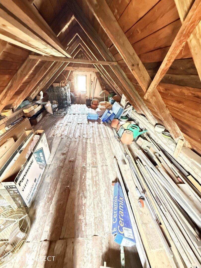 Geräumiger Dachboden mit sichtbaren Holzbalken, Holzfußboden und viel Stauraum.