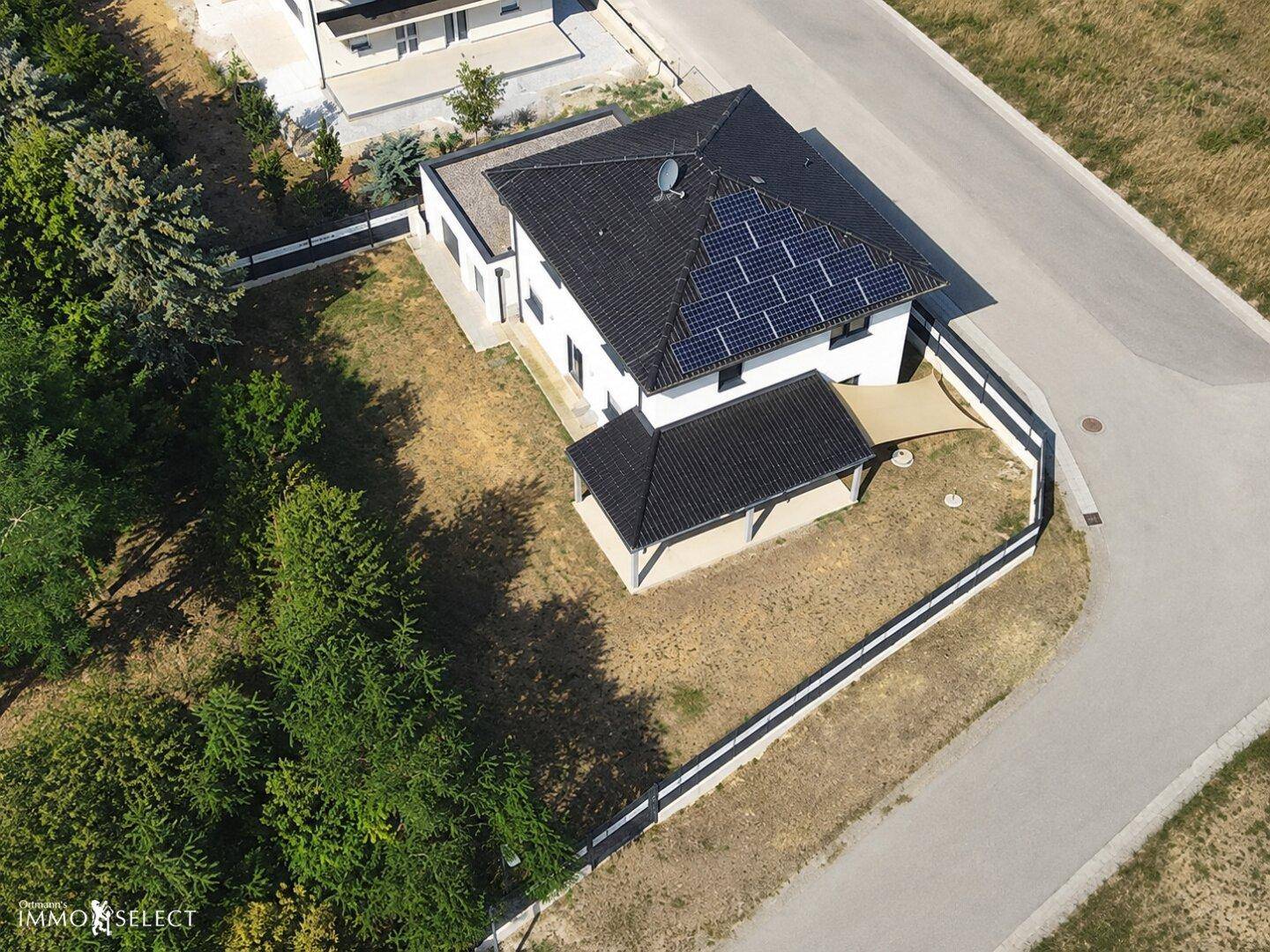 Dachansicht eines Einfamilienhauses mit Photovoltaikanlage und großem Garten.