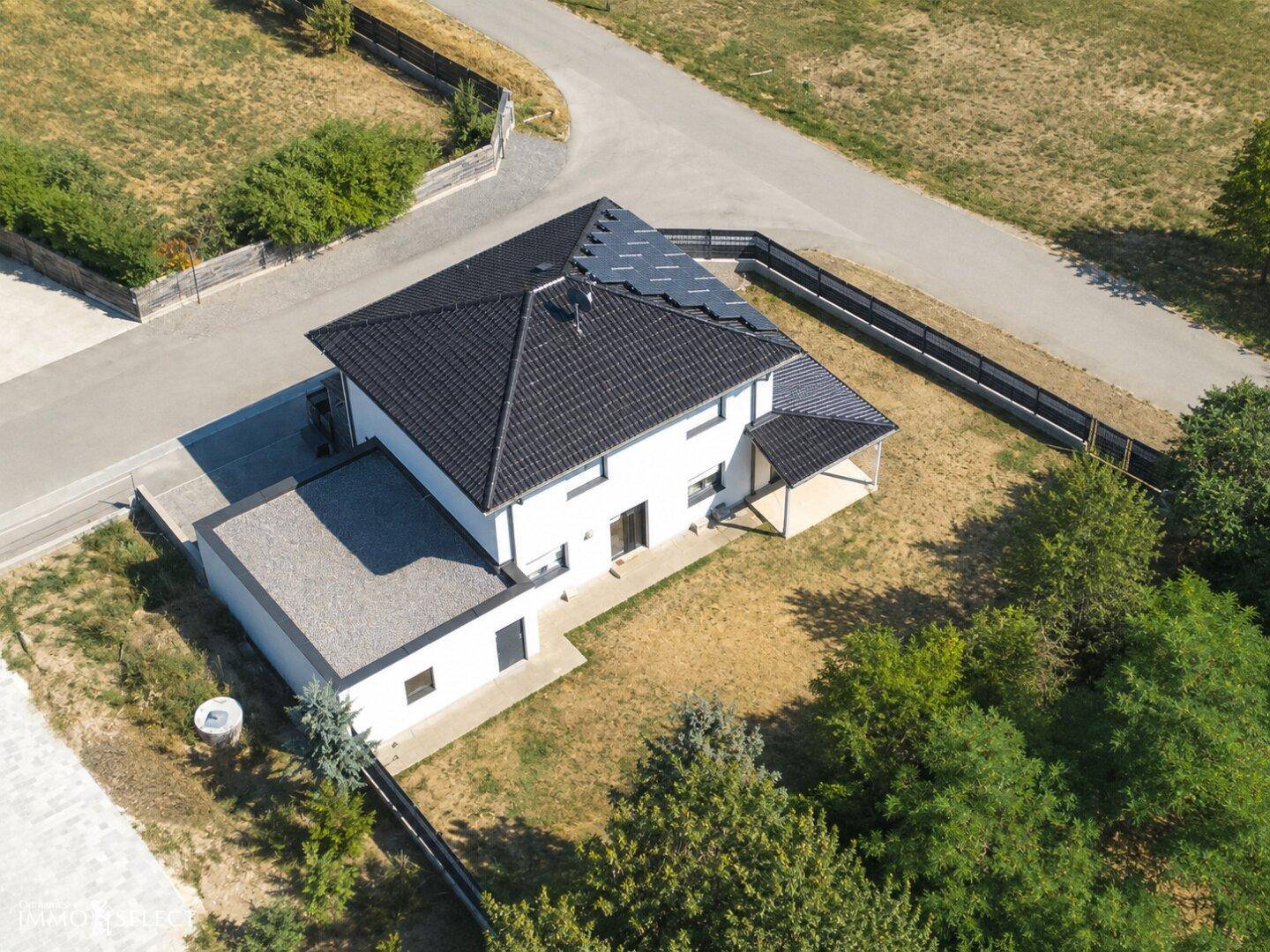Luftaufnahme des Einfamilienhauses von hinten mit Gartenbereich und angrenzender Natur.