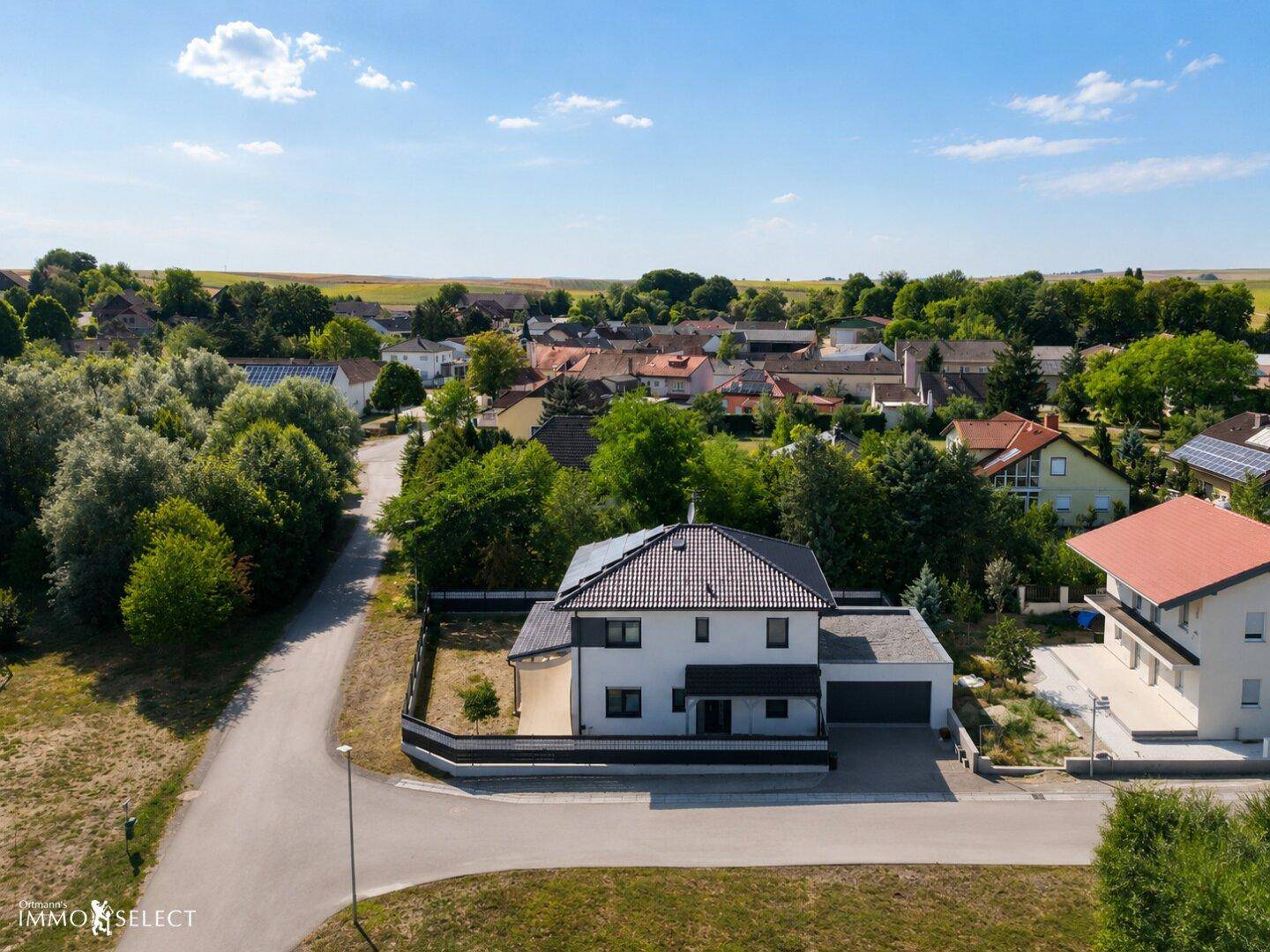 Weitläufige Luftaufnahme des Hauses in ländlicher Umgebung mit Blick auf ein Dorf.