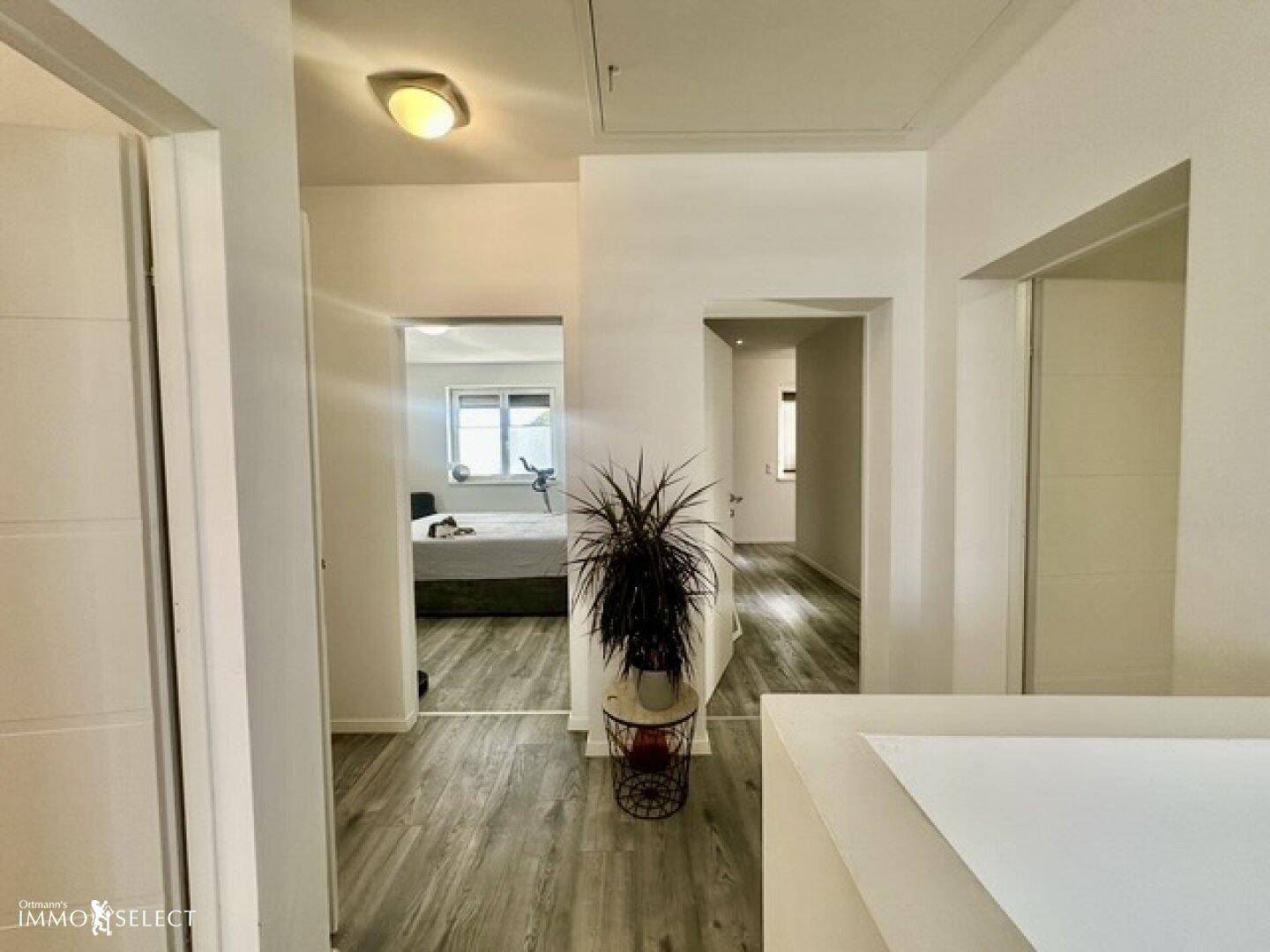 Heller Flur mit Laminatboden und Blick in angrenzende Zimmer.