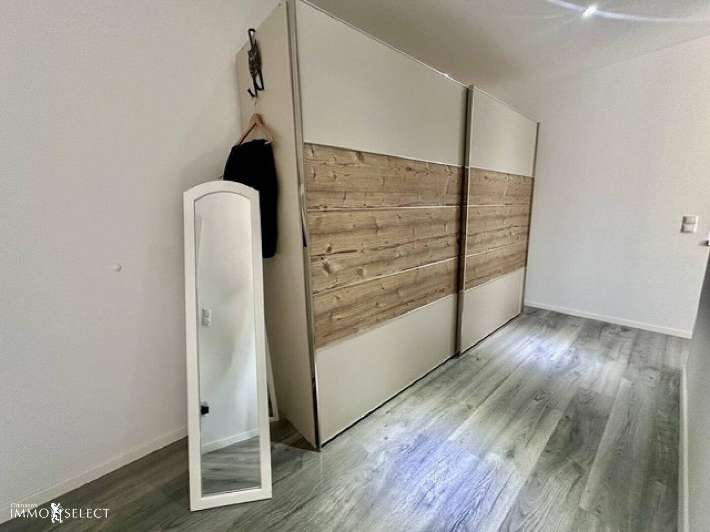 Flur mit großem Einbauschrank mit Holzdetails und einem Ganzkörperspiegel.