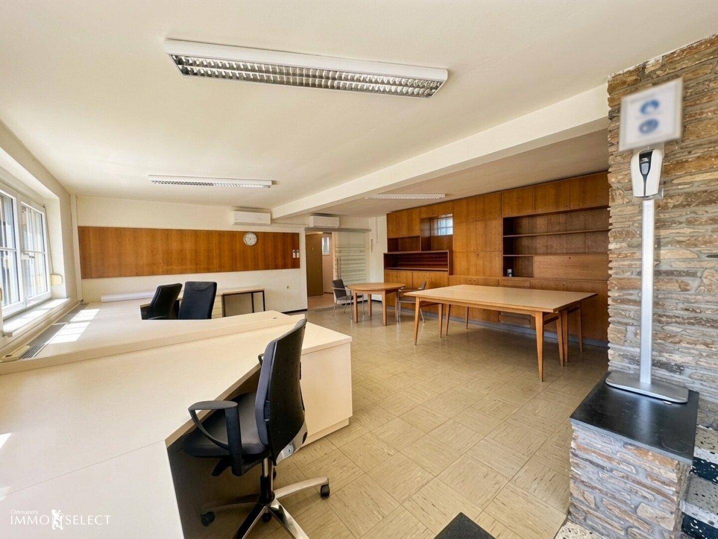 Geräumiges Büro mit Holzvertäfelung, Steinwandelementen und funktionalen Arbeitsbereichen.