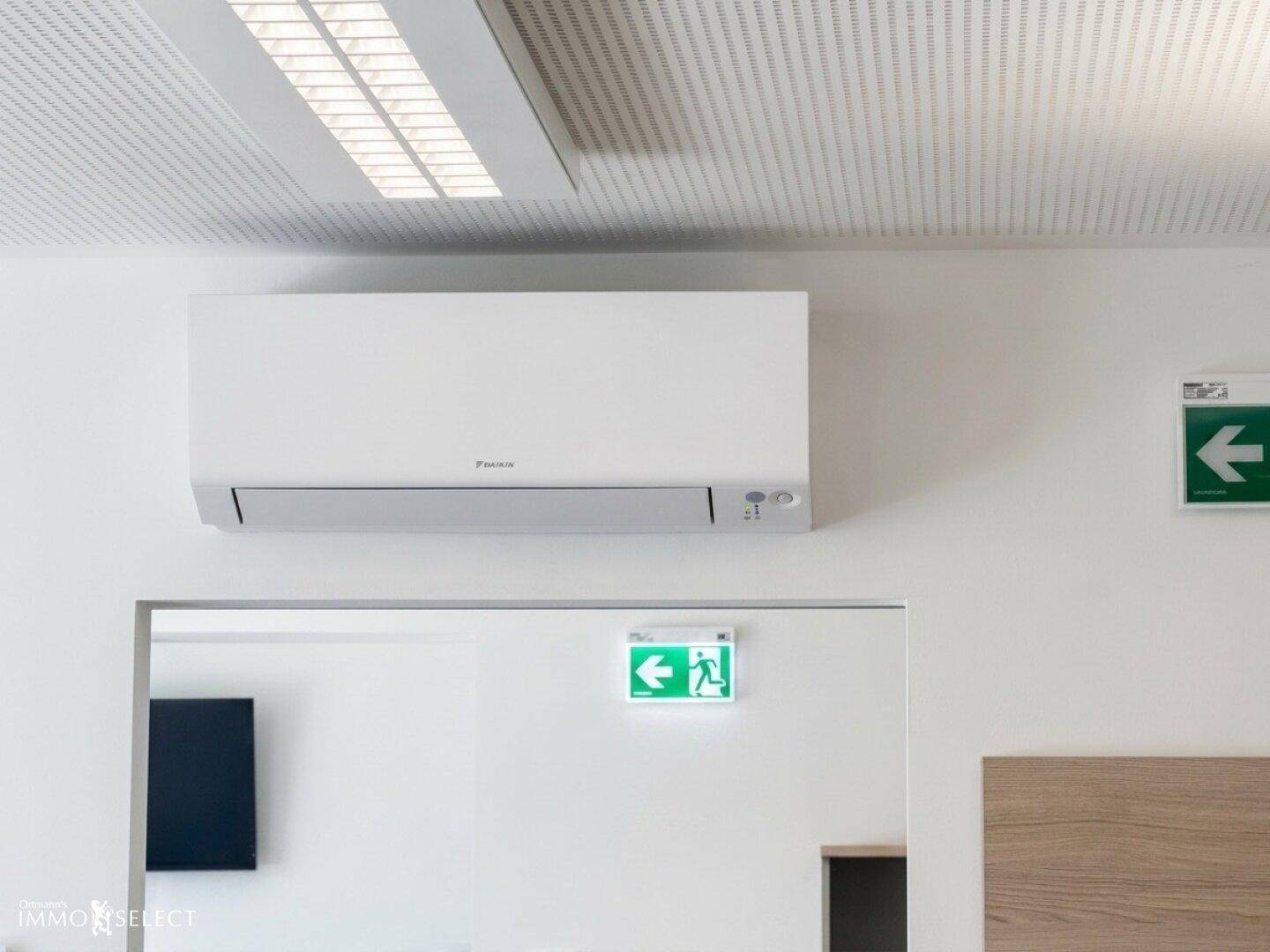 Detailaufnahme einer Klimaanlage an der Wand in einem Büroraum.