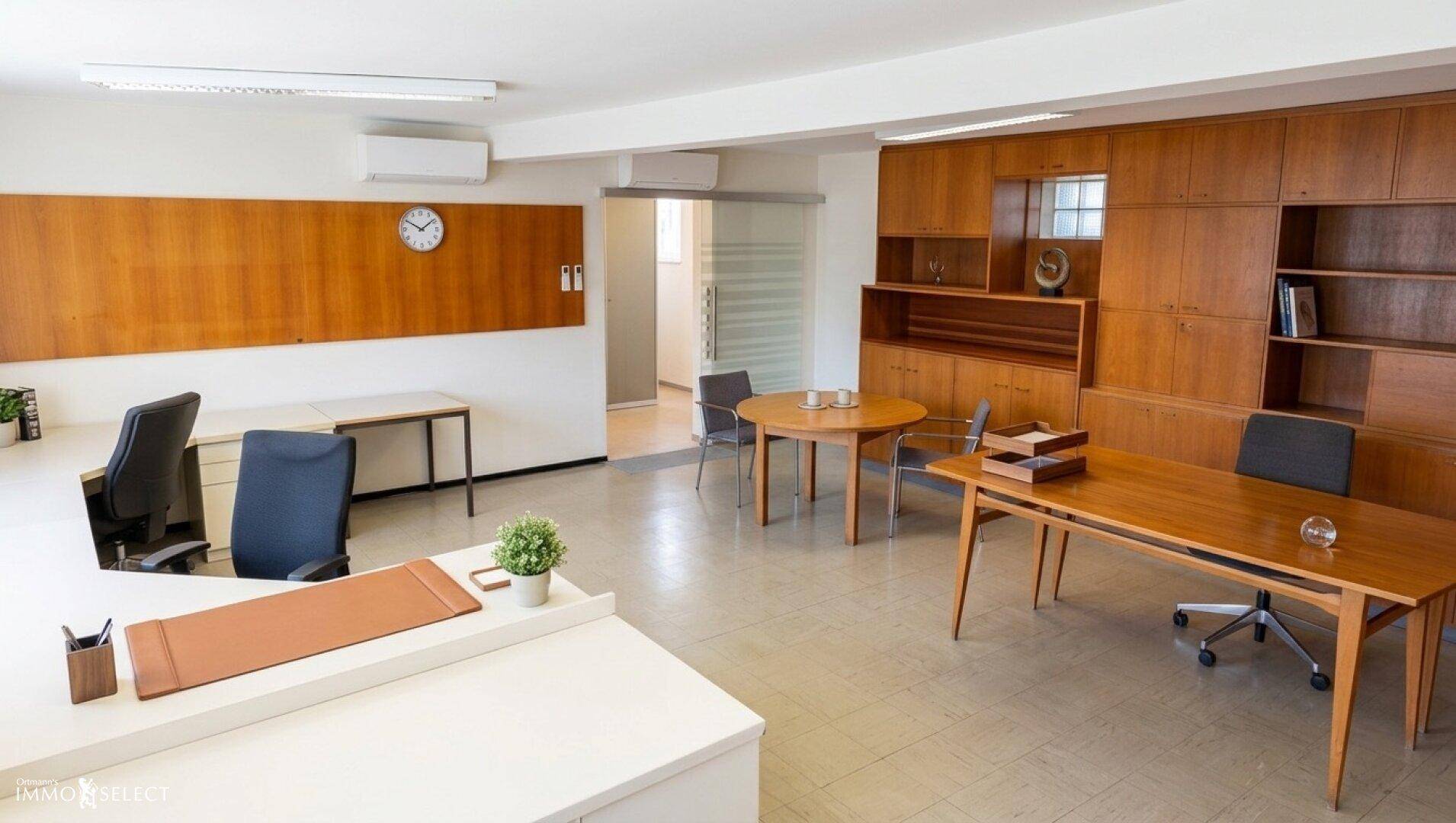 Geräumiges Büro mit Holzmöbeln, Schreibtischen und einer Holzvertäfelung an der Wand.