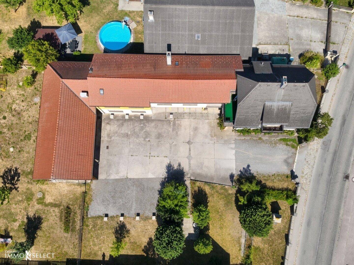 Weitläufige Luftaufnahme des Anwesens mit Hauptgebäude, Nebengebäude und Pool.