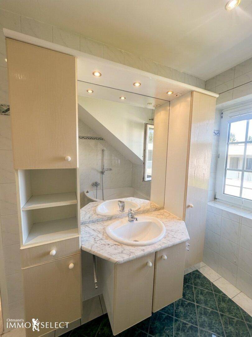 Badezimmerwaschtisch mit Marmorplatte, Einzelwaschbecken und Spiegelschrank.