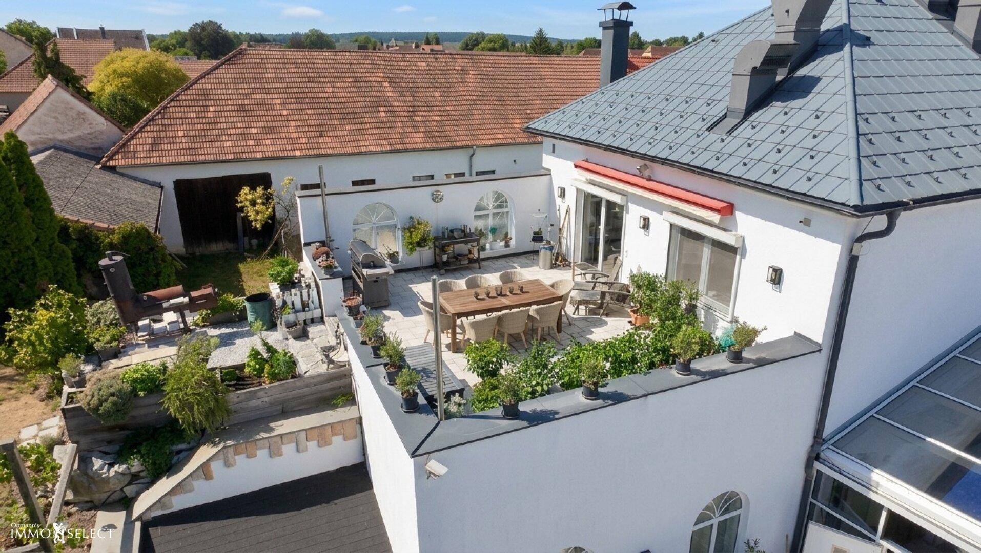 Luftaufnahme des Hauses mit großer Terrasse und Blick auf die Nachbarschaft.