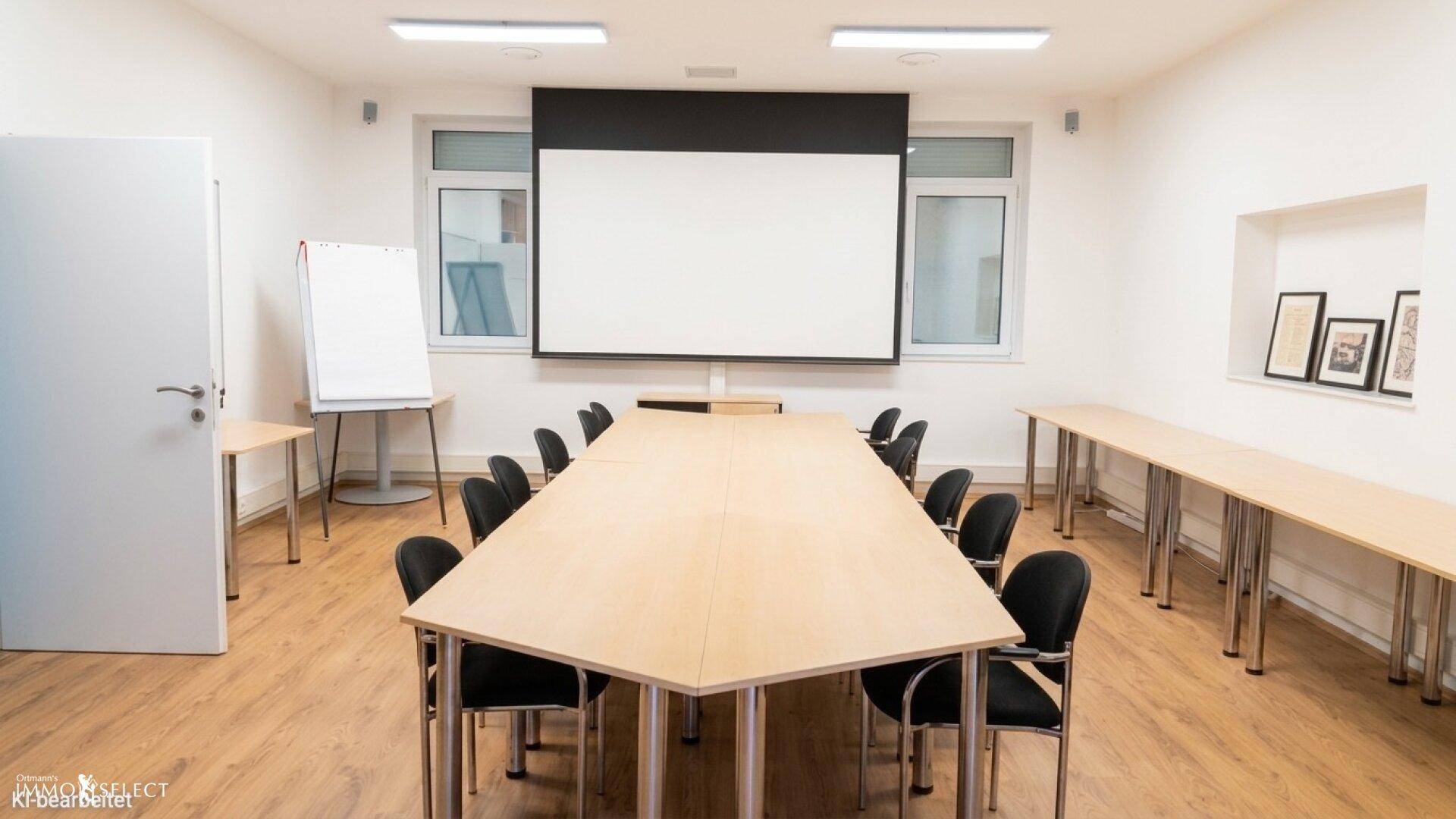 Moderner Konferenzraum mit großem Holztisch, Projektionsleinwand und hellem Ambiente.