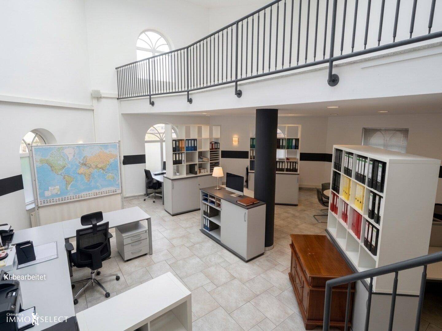 Offenes Büro mit Galerie, Weltkarte und verschiedenen Arbeitsplätzen in hellem Ambiente.