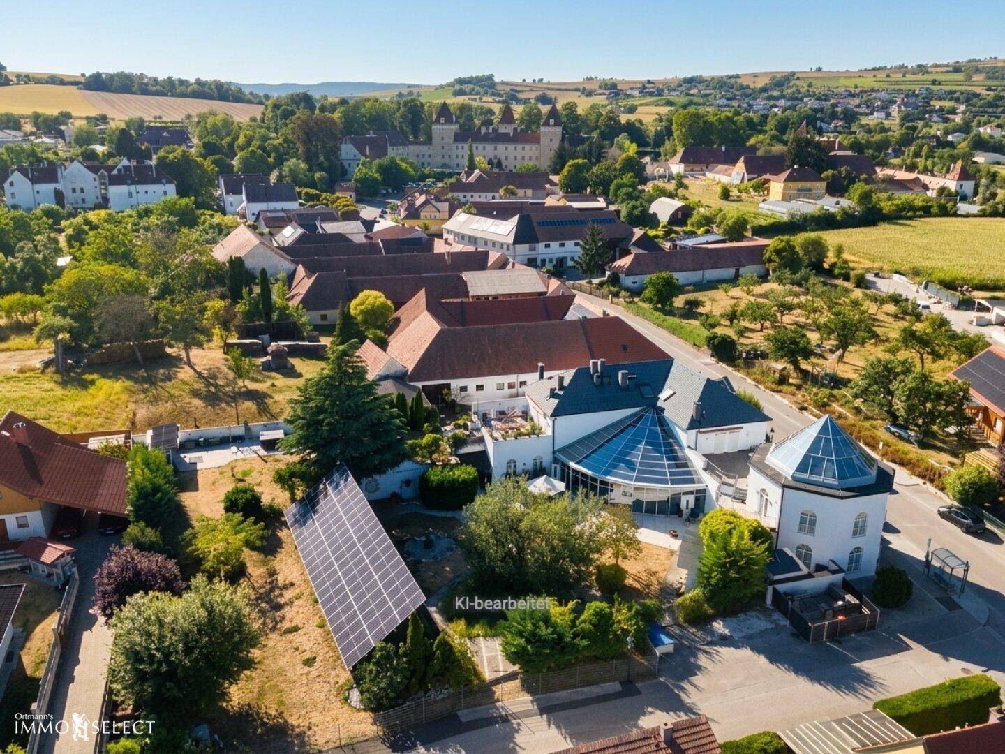 Luftaufnahme des Anwesens mit Solaranlage und Blick auf eine historische Burg in der Ferne.