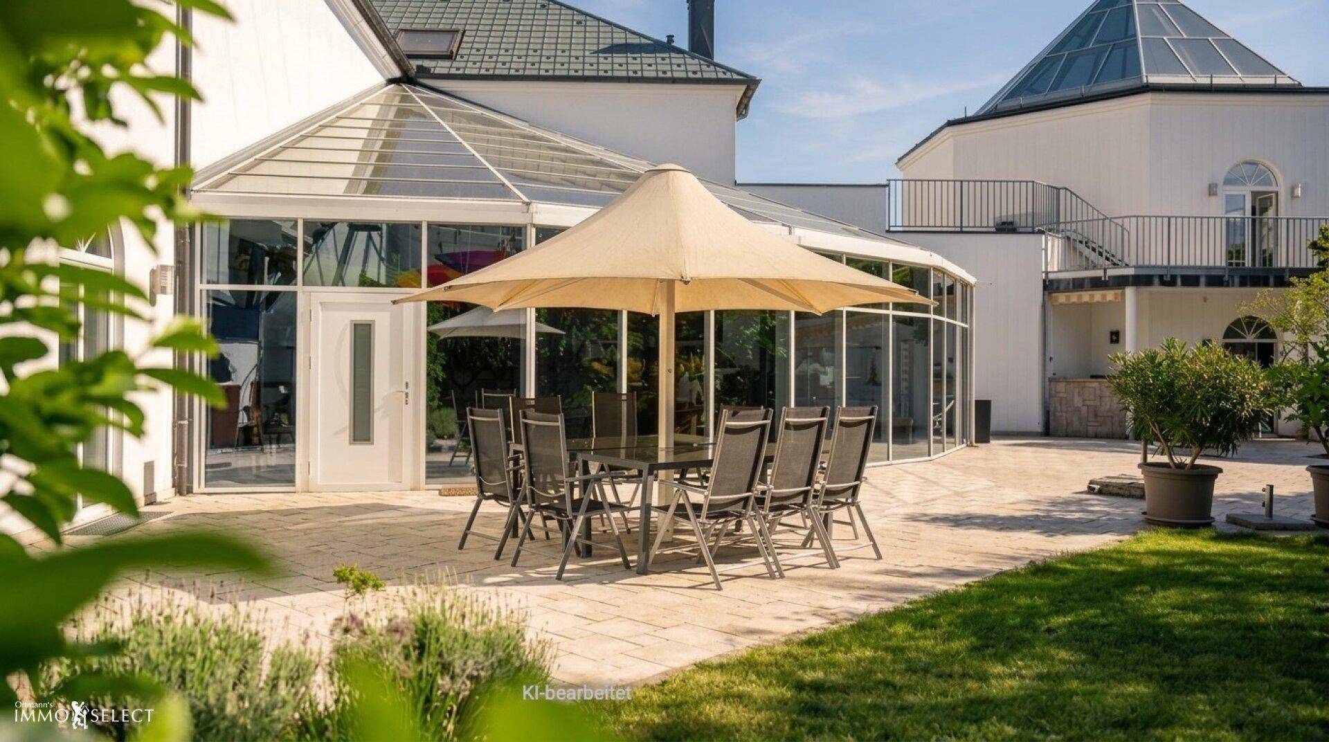 Gemütliche Terrasse mit großem Sonnenschirm und Esstisch, angrenzend an den Wintergarten.