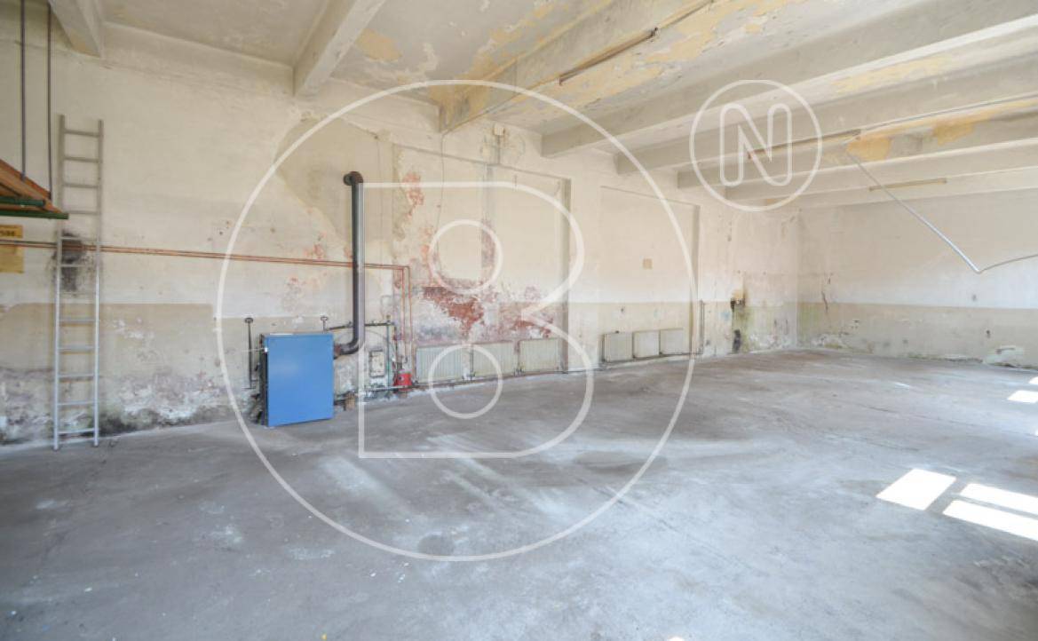 Großer Werkstattraum mit Betonboden und Heizungsanlage, bietet viel Platz.