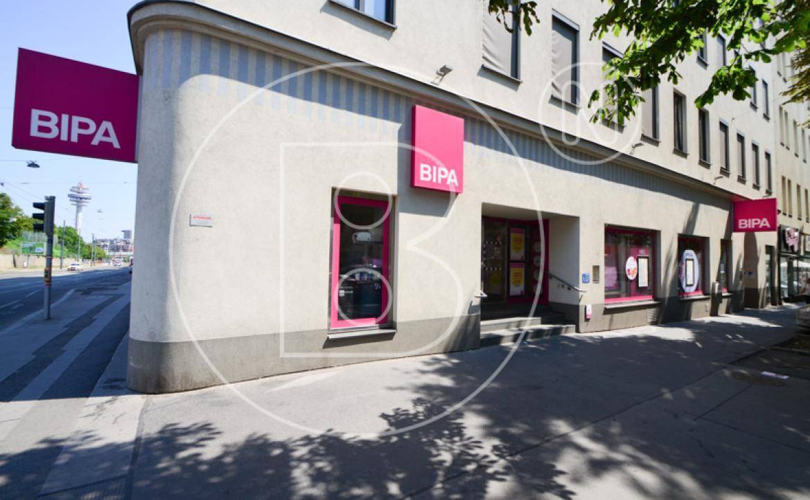 Modernes Geschäftsgebäude mit BIPA-Filiale im Erdgeschoss und großen Schaufenstern an einer Straßenecke.