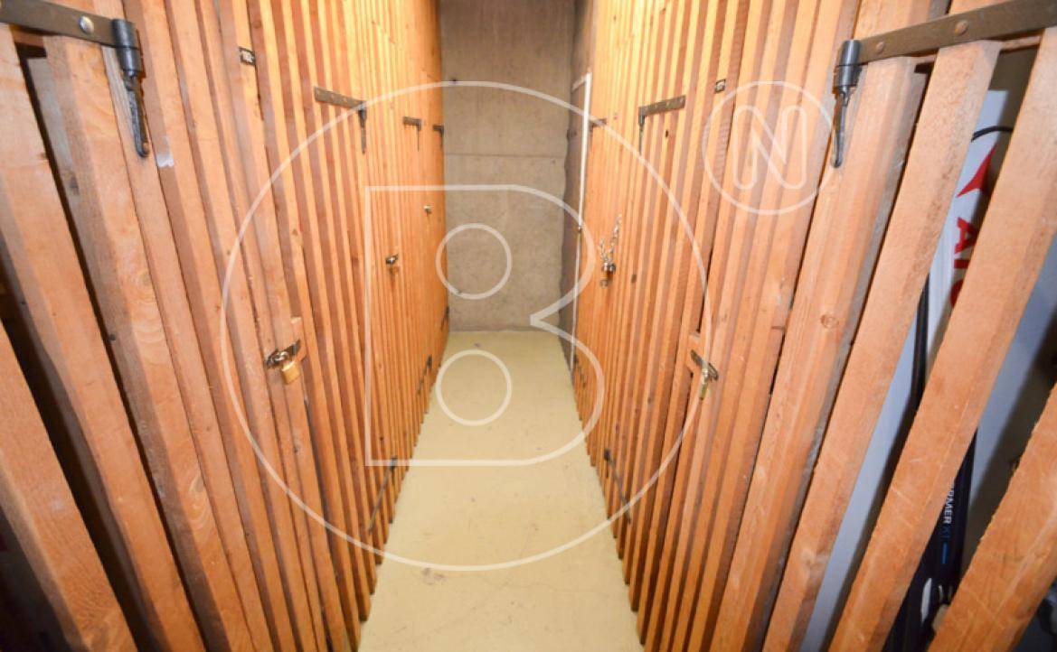Kellerabteil mit Holzverschlägen, bietet zusätzlichen Stauraum für Bewohner.
