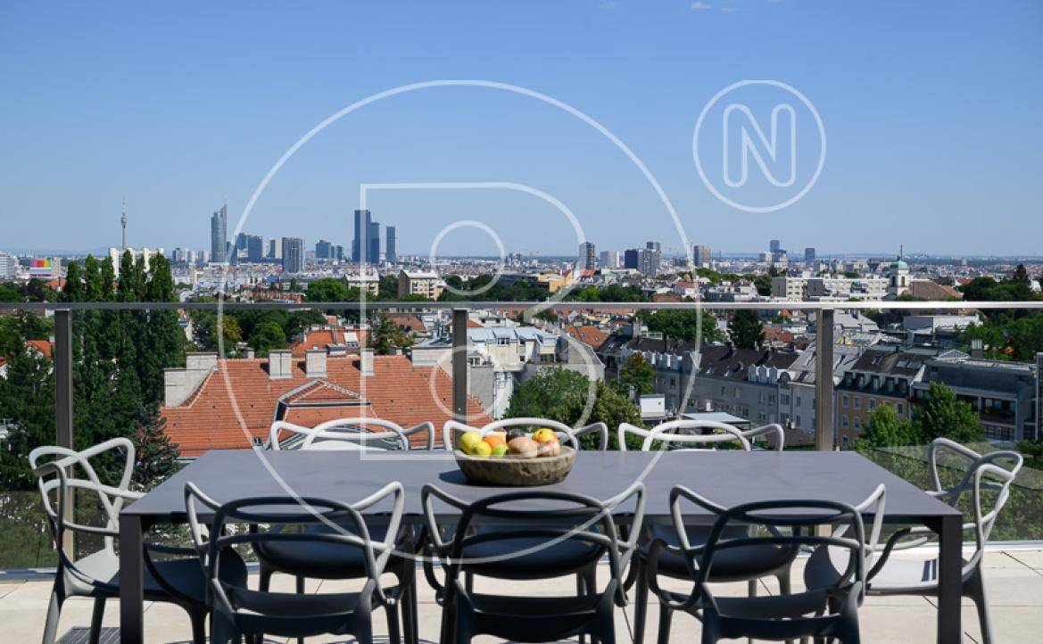Möblierte Dachterrasse mit Esstisch und Stühlen, bietet einen weiten Blick über die Stadt.