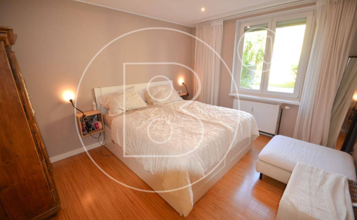 Gemütliches Schlafzimmer mit Doppelbett, Holzschrank und hellem Holzboden.