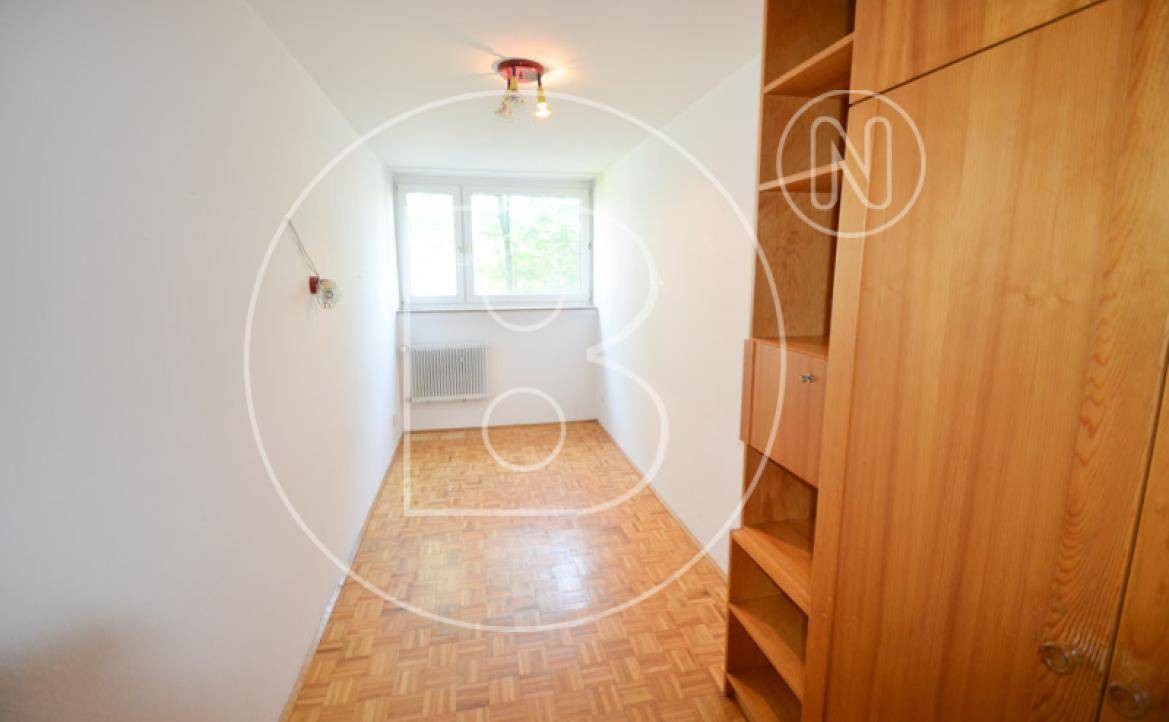 Kleines Zimmer mit Parkettboden, Fenster und einem Holzregal für zusätzlichen Stauraum.