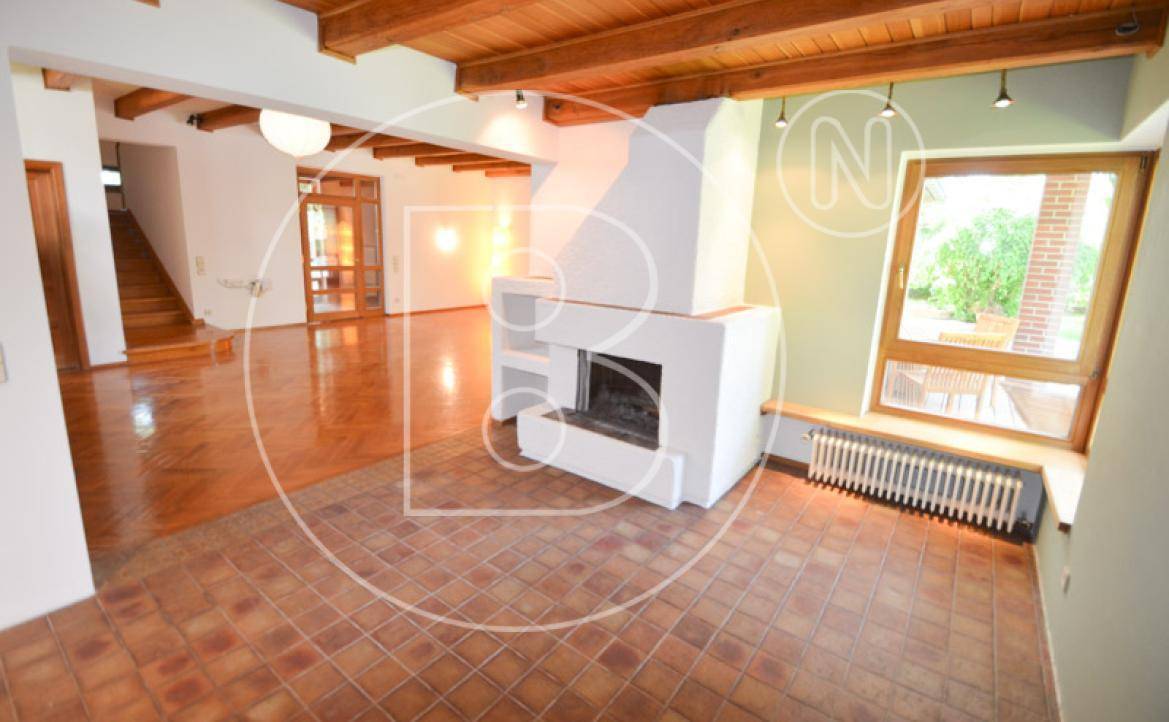 Wohnbereich mit modernem Kamin, Terrakotta-Fliesen und großem Fenster mit Gartenblick.