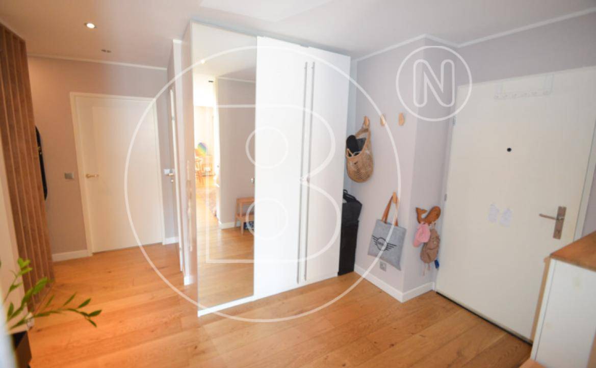Eingangsbereich mit Haustür, Einbauschrank und großem Spiegel.