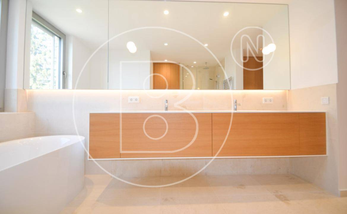 Modernes Badezimmer mit Doppelwaschbecken, großem Spiegel und Badewanne.